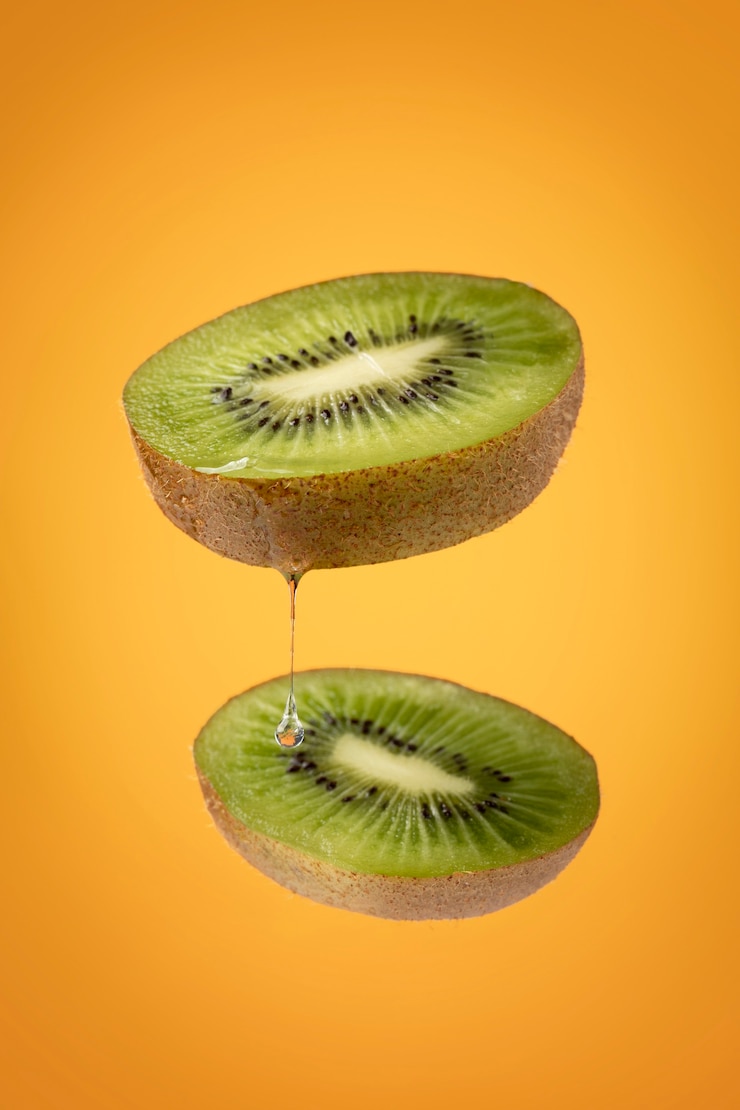 Kostenlose Foto schwimmende geschnittene kiwi-früchte mit klarem hintergrund