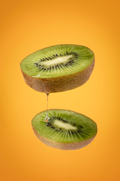 Schwimmende geschnittene Kiwis mit klarem Hintergrund