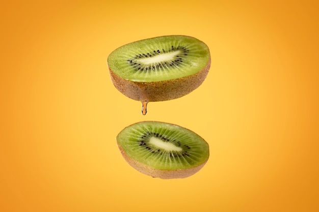 Schwimmende geschnittene Kiwis mit klarem Hintergrund