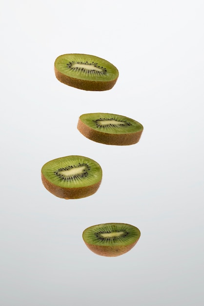 Schwimmende geschnittene Kiwis mit klarem Hintergrund