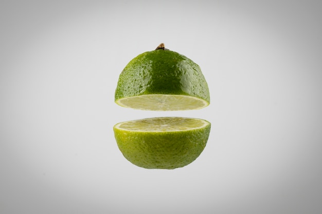 Schwimmende geschnittene Limette mit klarem Hintergrund
