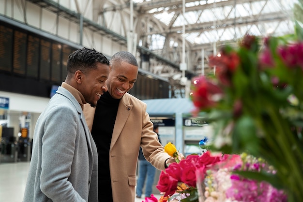 Kostenloses Foto schwules paar kauft blumen in der stadt bei einem date