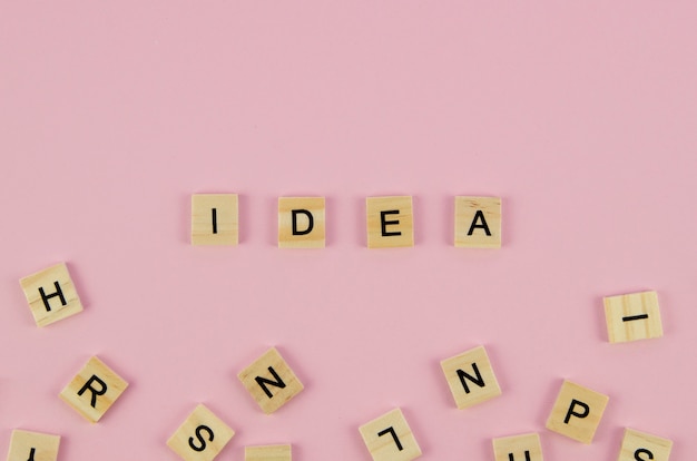 Scrabblebuchstaben und Ideenwortkonzept auf rosa Hintergrund