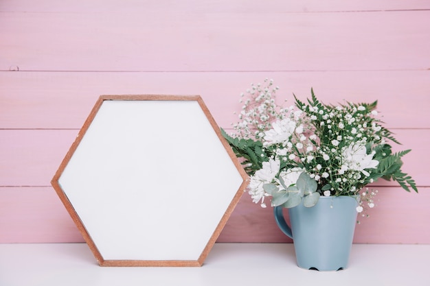 Sechseckiger Rahmen neben Blumentopf