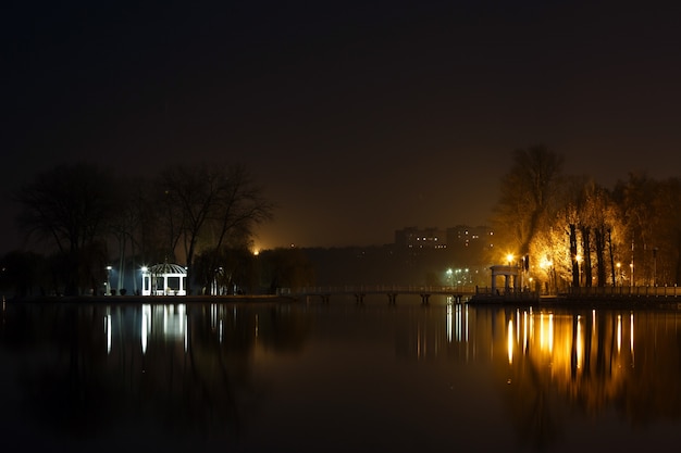 See in der Nacht mit einem Haus und Lichter