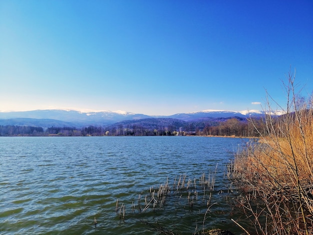 See umgeben von Hügeln und Gras unter dem Sonnenlicht und einem blauen Himmel in Polen