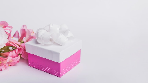 Kostenloses Foto seeroseblume und geschenkbox lokalisiert auf weißem hintergrund