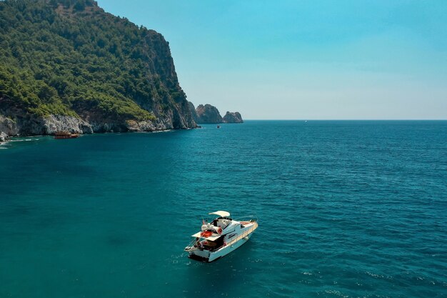 Segelboot im Meer im Abendsonnenlicht über schönen großen Bergen, luxuriöses Sommerabenteuer, aktiver Urlaub im Mittelmeer, Türkei