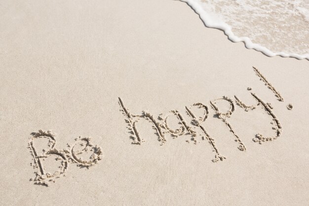 Seien Sie glücklich auf Sand geschrieben