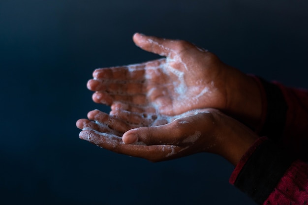 Seifenhände einer Person - Wichtigkeit des Händewaschens während der Coronavirus-Pandemie