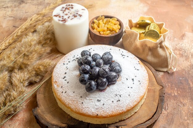 Seite Nahaufnahme Ansicht ein Kuchen ein Kuchen auf dem Holzbrett grüne Rosinen Bonbons Ährchen