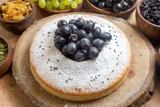 Seite Nahaufnahme Ansicht eines Kuchens ein Kuchen auf dem Brett Schalen von Trauben Kürbiskern Rosinen