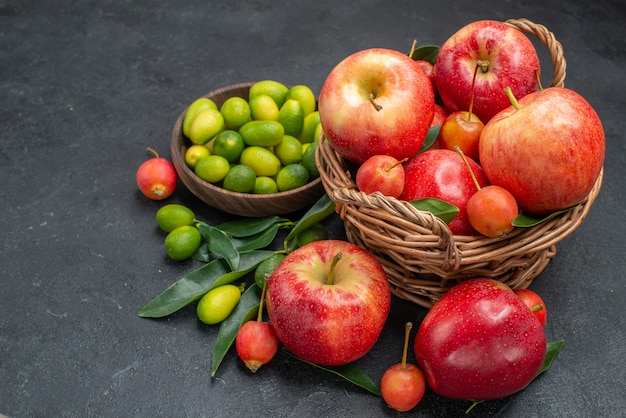 Seite Nahaufnahme Ansicht Früchte braune Schüssel Zitrusfrüchte Korb von Kirschen und Äpfeln