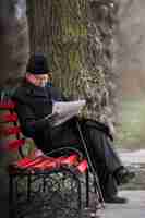 Kostenloses Foto seitenansicht älterer mann liest zeitung