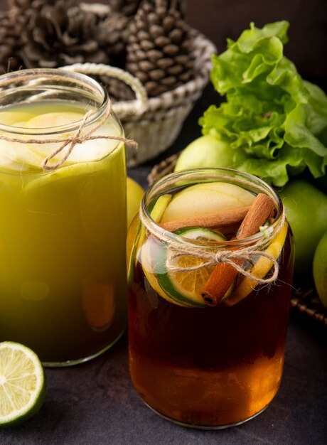 Seitenansicht Apfel trinkt frischen Apfelsaft und Zitronentee mit Limettenzimtgrünapfel und Salat auf Tafel
