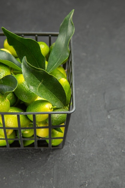 Kostenloses Foto seitenansicht aus der ferne früchte früchte mit blättern im korb