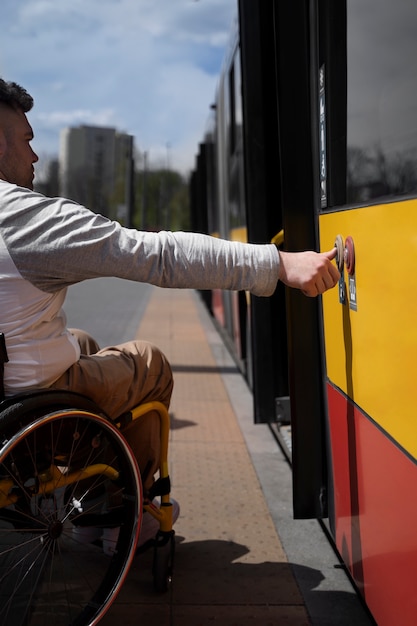 Kostenloses Foto seitenansicht behinderter mann, der auf den bus wartet