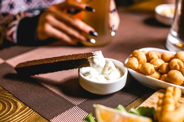 Seitenansicht Bier Snacks Crouton von Schwarzbrot mit Sauce und gebratenen Erbsen