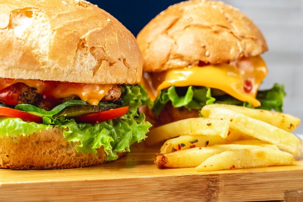 Seitenansicht Burger Hühnerpastetchen mit eingelegter Käsetomate Gurke und Salat zwischen Brotbrötchen