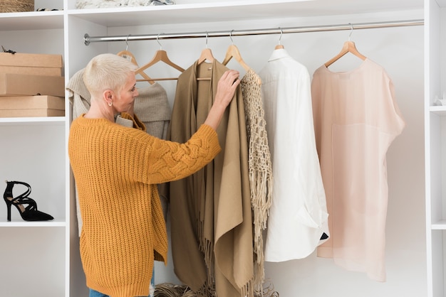 Seitenansicht der älteren Frau ihre Kleidung durchlaufen