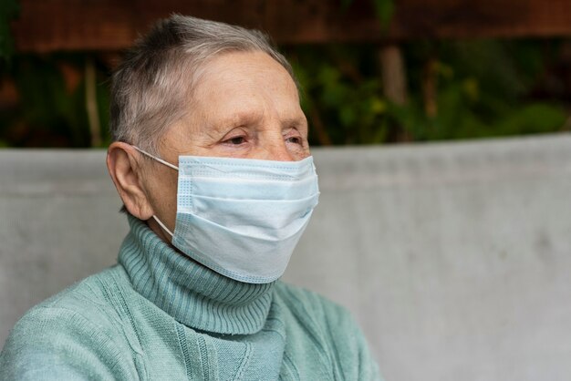 Seitenansicht der älteren Frau mit medizinischer Maske und Kopienraum