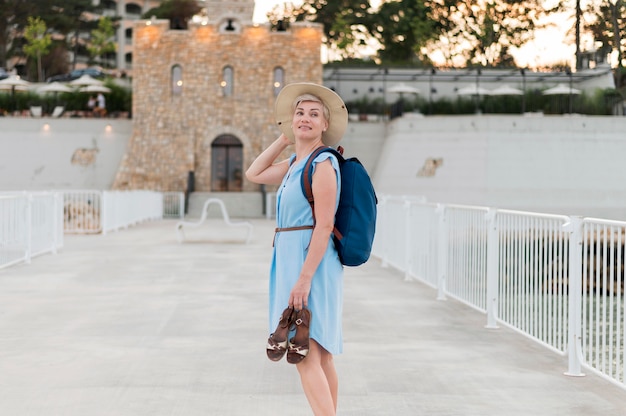 Kostenloses Foto seitenansicht der älteren touristenfrau, die schuhe hält