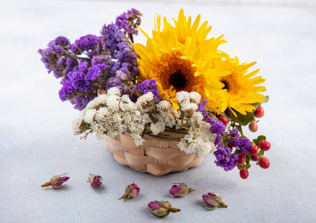 Seitenansicht der Blumen im Korb auf weißer Oberfläche