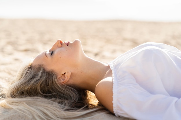 Seitenansicht der Frau, die am Strand entspannt