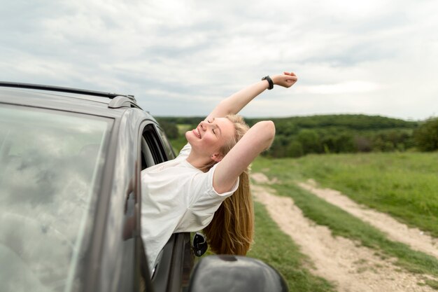 Seitenansicht der Frau, die eine Autofahrt genießt