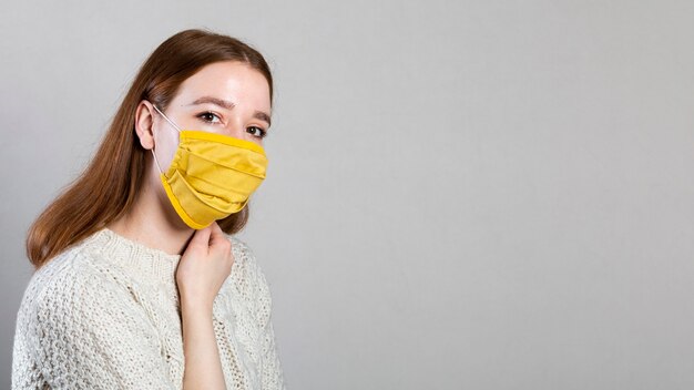 Seitenansicht der Frau, die eine medizinische Maske mit Kopienraum trägt