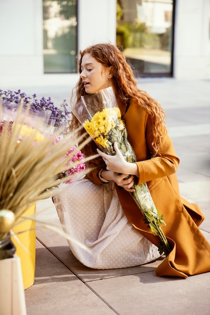 Seitenansicht der Frau, die Frühlingsblumen im Freien erhält