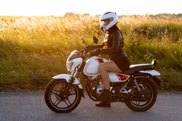 Seitenansicht der Frau, die Motorrad mit Helm auf reitet
