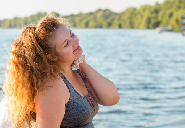 Seitenansicht der Frau, die nach dem Ausarbeiten am See mit Kopierraum ruht