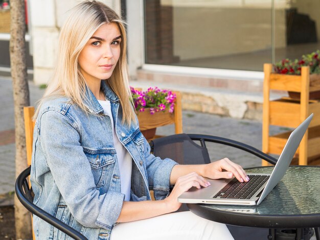 Seitenansicht der Frau, die während der Arbeit am Laptop im Freien aufwirft