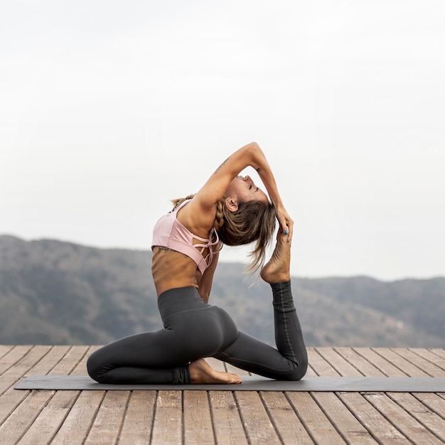 Seitenansicht der Frau, die Yoga im Freien tut