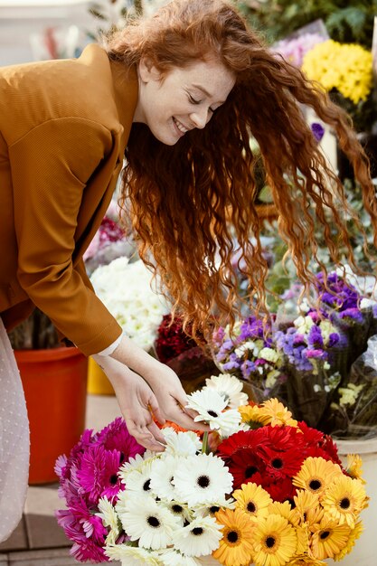 Seitenansicht der Frau draußen im Frühjahr mit Blumenstrauß