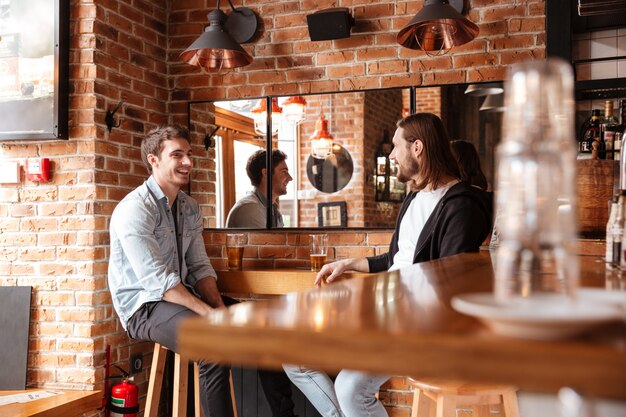 Seitenansicht der Freunde in der Bar nahe dem Spiegel