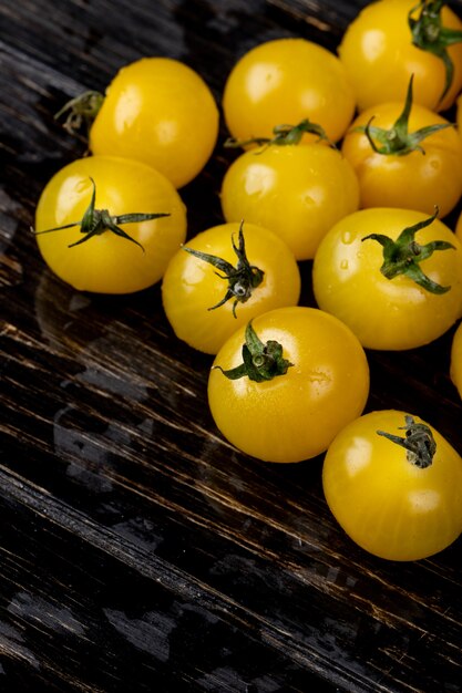 Seitenansicht der gelben Tomaten auf Holzoberfläche