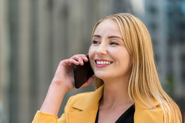 Seitenansicht der Geschäftsfrau, die auf Smartphone spricht