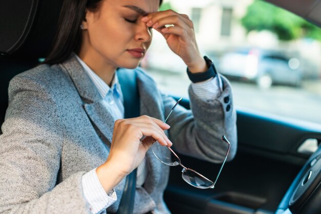Seitenansicht der Geschäftsfrau, die Kopfschmerzen im Auto hat