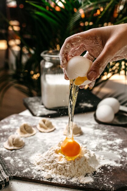 Seitenansicht der Herstellung von türkischem Manti mit Teig und Eigelb