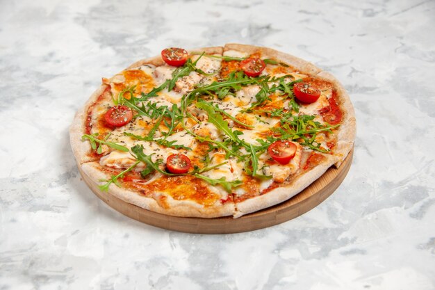 Seitenansicht der köstlichen Pizza mit Tomatengrün auf befleckter weißer Oberfläche