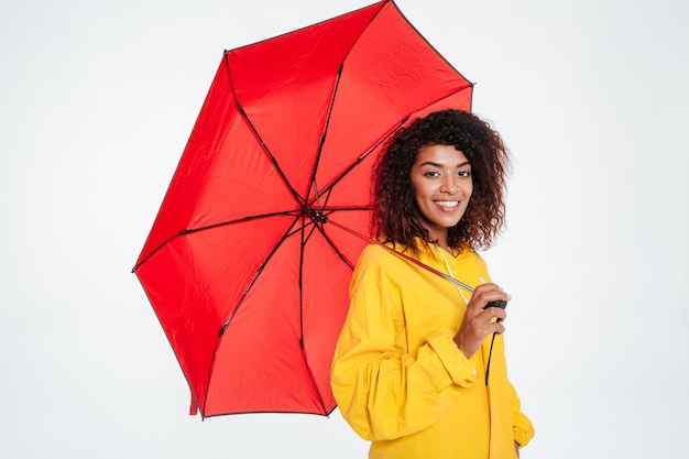 Seitenansicht der lächelnden afrikanischen Frau in der Regenmantelaufstellung