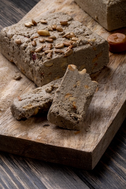 Seitenansicht der leckeren Halva mit Sonnenblumenkernen auf einem Holzbrett