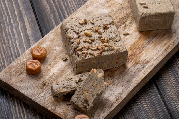 Seitenansicht der leckeren Halva mit Sonnenblumenkernen auf einem Holzbrett