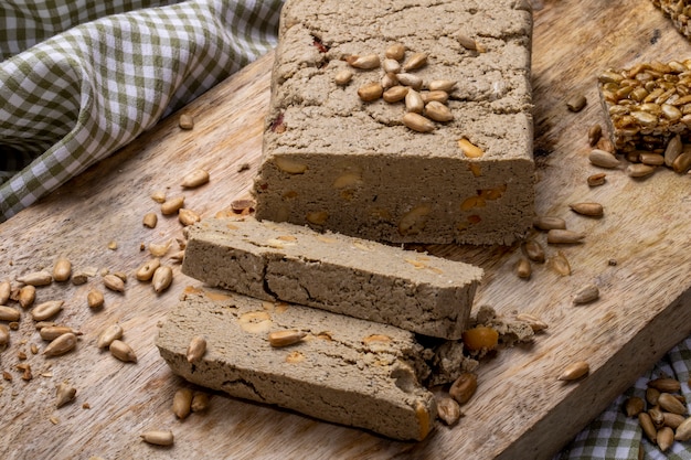 Seitenansicht der leckeren Halva-Scheiben mit Sonnenblumenkernen auf einem Holzbrett