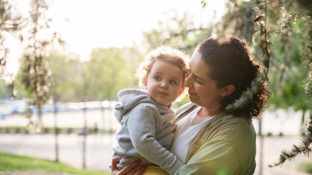 Seitenansicht der lgbt Mutter draußen im Park mit ihrem Kind