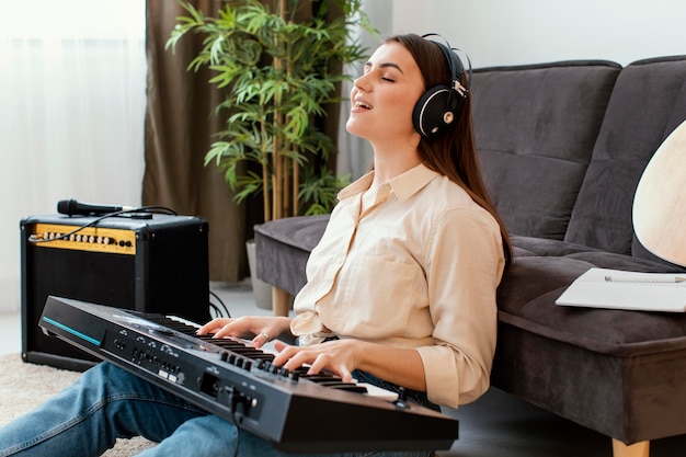 Seitenansicht der Musikerin, die Klaviertastatur singt und spielt