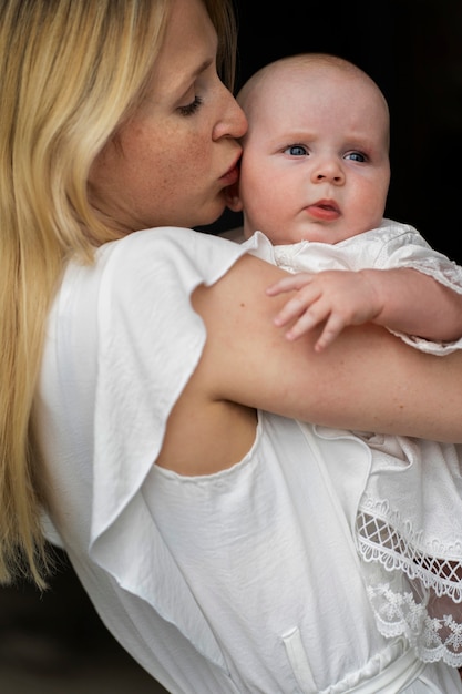 Seitenansicht der Mutter, die das Baby auf die Wange küsst