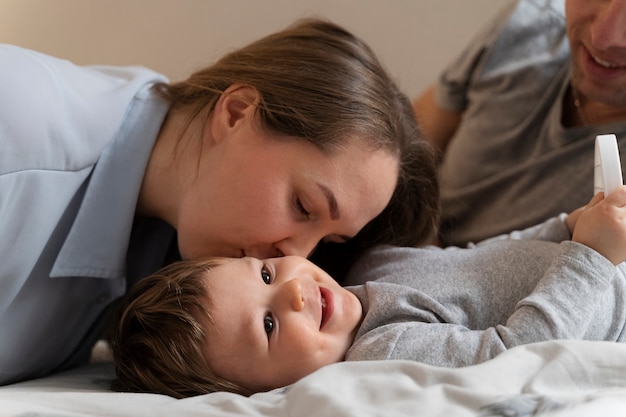 Seitenansicht der Mutter, die das Kind auf der Wange scherzt